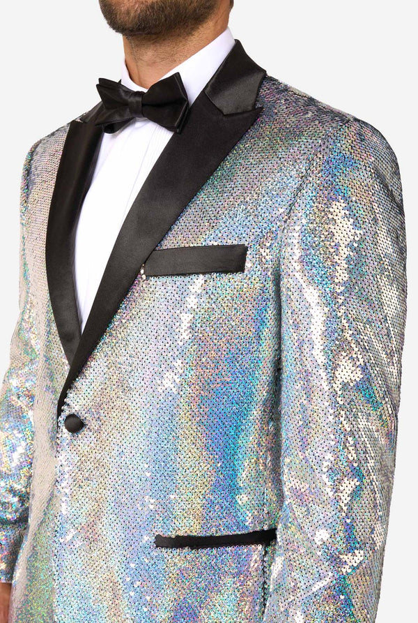 Man in sequin smoking met holografische zilveren pailletten en zwarte satijnen revers, gecombineerd met een wit overhemd, zwarte vlinderdas en zwarte broek. Close-up. 
