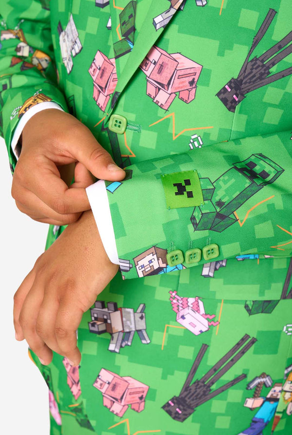 Een tienerjongen in een felgroen Minecraft-pak met iconische personages, waaronder Creepers en Steve - Close up van de mouwen