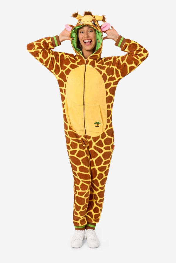 Een lachende vrouw draagt een bruine en gele onesie voor volwassenen die is ontworpen als een giraffe. De onesie heeft een capuchon die op een giraffekop lijkt en giraffedetails, perfect voor gezellig loungen of verkleedfeestjes. De vrouw heeft de capuchon op haar hoofd. Volledig lichaam foto.