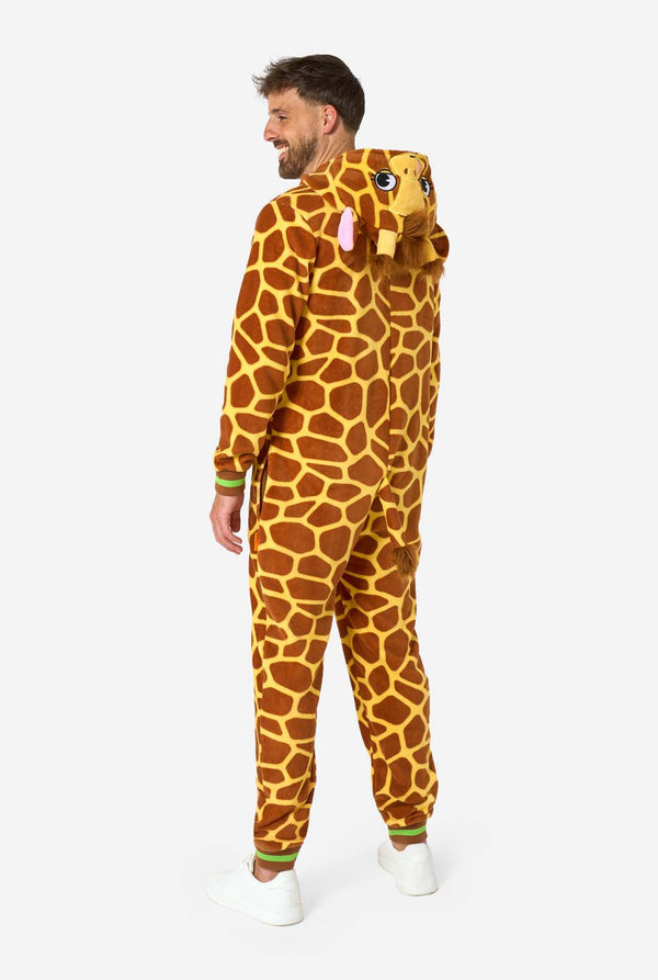 Een glimlachende man draagt ​​een bruin-gele volwassen onesie ontworpen als een giraffe. De onesie heeft een capuchon die lijkt op een giraffenkop en giraffedetails, perfect voor gezellig loungen of verkleedfeestjes. Volledig lichaamsbeeld met de zijkant.