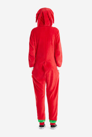 Een vrouw draagt ​​een felrode Knuckles the Echidna onesie voor volwassenen, een gezellige en speelse outfit geïnspireerd op het beroemde personage uit de Sonic the Hedgehog-serie. De onesie is voorzien van de kenmerkende witte borstpatch van Knuckles en heeft een capuchon die het gezicht van Knuckles laat zien, compleet met zijn expressieve ogen en lange rode dreads. De ritssluiting aan de voorkant zorgt voor gemakkelijk dragen. Zicht vanaf de achterkant