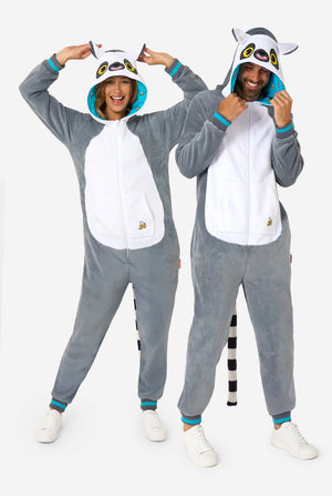Een man en vrouw dragen een grijze en witte maki onesie voor volwassenen met speelse capuchondetails en knus, zacht materiaal, perfect om in te loungen of voor verkleedpartijen. Inclusief zwart-witte staart. De capuchon staat op hun hoofd. Volledig lichaam foto
