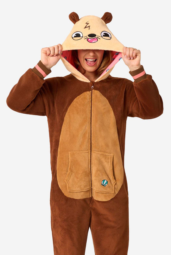 Een lachende vrouw draagt ​​een bruine onesie voor volwassenen met de afbeelding van een otter. De onesie heeft een capuchon met oren, een schattig gezichtje en speelse otterdetails, perfect voor een gezellige loungesessie of verkleedpartijtjes.