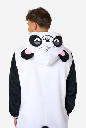 Een glimlachende man die een volwassen onesie met panda-thema draagt. Deze gezellige onesie heeft de zwart-witte pandakleuren met een speelse capuchon met panda-oren en een schattig gezichtje. Perfect voor loungen of leuke verkleedgelegenheden. Uitzicht vanaf de achterkant en capuchon op zijn rug.
