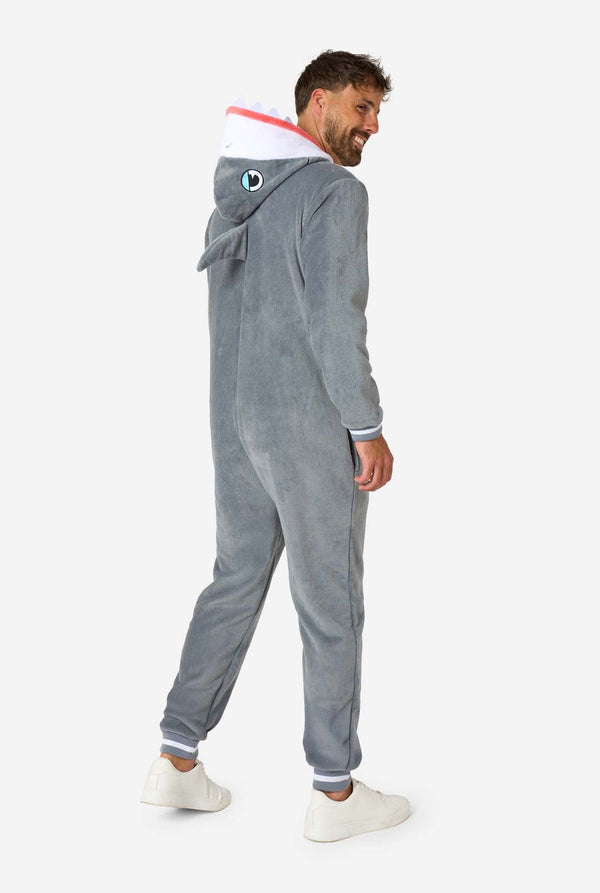 Een man draagt ​​een grijze en witte haaienonesie voor volwassenen met speelse capuchondetails en gezellig, zacht materiaal, perfect voor loungen of verkleedevenementen. Volledig lichaamsbeeld vanaf de achterkant.