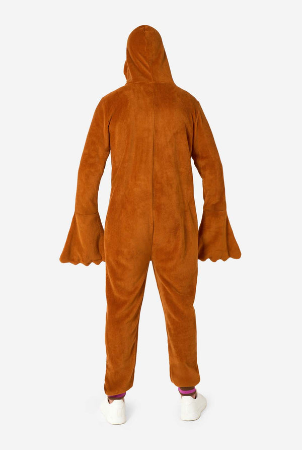 Een vrolijke man in een bruine volwassen onesie uitgevoerd in de vorm van een walrus. De onesie heeft een capuchon met hoektanden, gestikte handschoenen die op poten lijken en speelse walrusdetails, perfect voor gezellig loungen of verkleedfeestjes. Volledig lichaamsbeeld vanaf de achterkant.