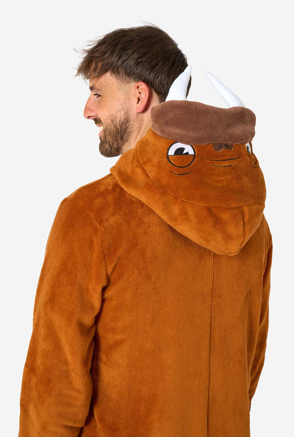 Een vrolijke man in een bruine volwassen onesie uitgevoerd in de vorm van een walrus. De onesie heeft een capuchon met hoektanden, gestikte handschoenen die op poten lijken en speelse walrusdetails, perfect voor gezellig loungen of verkleedfeestjes. Bovenlichaam close-up, capuchon op zijn rug.