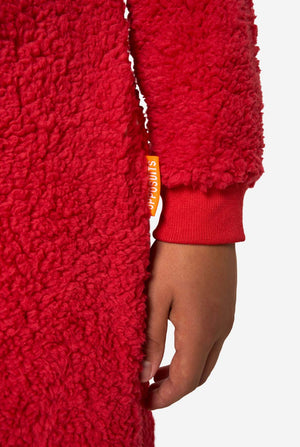 Jongen draagt rode pluche Elmo onesie, gefocust op de mouwen