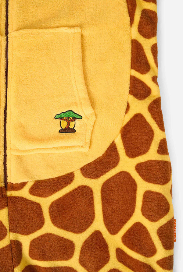 Een lachend kind draagt ​​een bruin-gele kinderonesie ontworpen als een giraffe. De onesie heeft een capuchon die lijkt op een giraffenkop. Close-up.