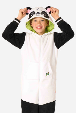 Een glimlachend kind dat een kinderonesie met panda-thema draagt. Deze gezellige onesie heeft de zwart-witte pandakleuren met een speelse capuchon met panda-oren en een schattig gezichtje. Perfect voor loungen of leuke verkleedgelegenheden.