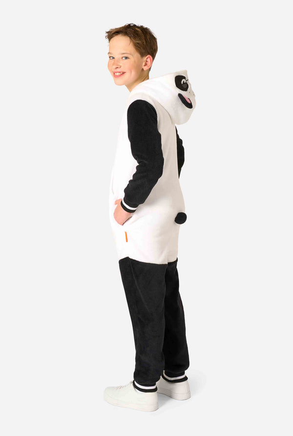 Een glimlachend kind dat een kinderonesie met panda-thema draagt. Deze gezellige onesie heeft de zwart-witte pandakleuren met een speelse capuchon met panda-oren en een schattig gezichtje. Perfect voor loungen of leuke verkleedgelegenheden. Afbeelding van volledige lichaamszijde, capuchon naar beneden.