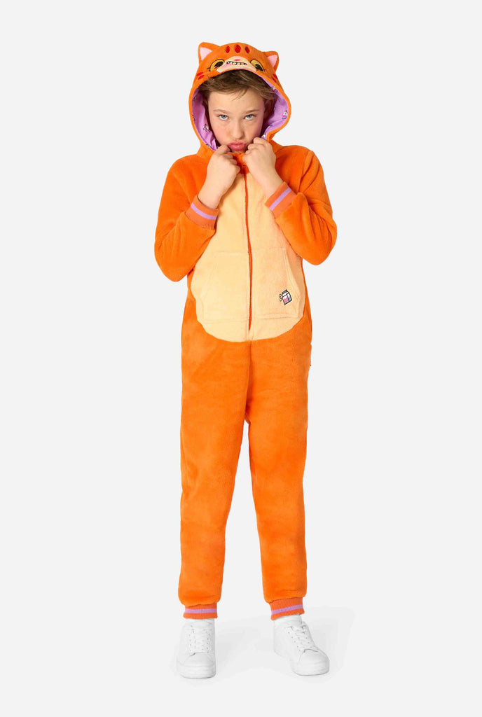 Kind draagt ​​een speels unisex kinderonesie in de vorm van een rood-oranje kat, met een capuchon met een cartoonkattengezicht, oren en een lichtbeige buikpaneel, dat een gek gezicht vormt tegen een effen achtergrond.