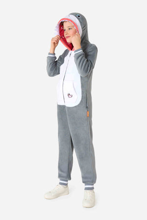 Een kind draagt ​​een grijze en witte kinderonesie met een haai, speelse capuchondetails en gezellig, zacht materiaal, perfect voor loungen of verkleedevenementen. Volledig lichaamsbeeld.