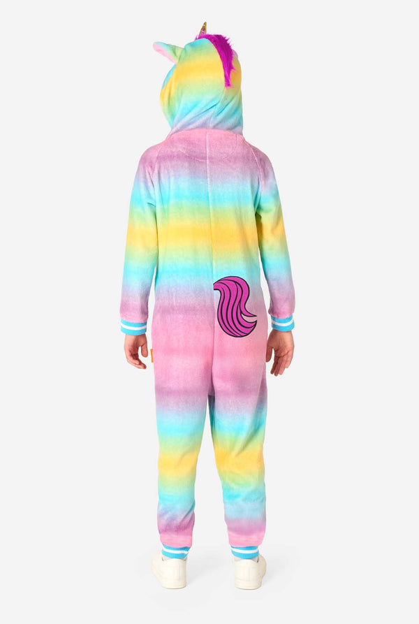 Een lachend kind draagt ​​een witte, roze, blauwe en gele kinderonesie ontworpen als eenhoorn. De Unicorn onesie heeft een capuchon die lijkt op een eenhoornkop en andere speelse details. Uitzicht vanaf de achterkant, volledig lichaam.