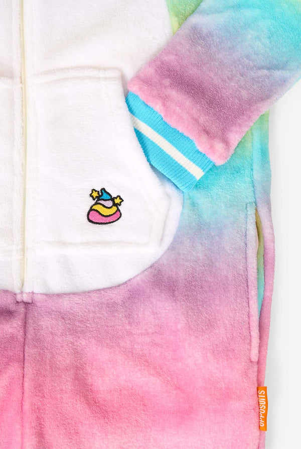 Een lachend kind draagt ​​een witte, roze, blauwe en gele kinderonesie ontworpen als eenhoorn. De Unicorn onesie heeft een capuchon die lijkt op een eenhoornkop en andere speelse details. Close-upzak.