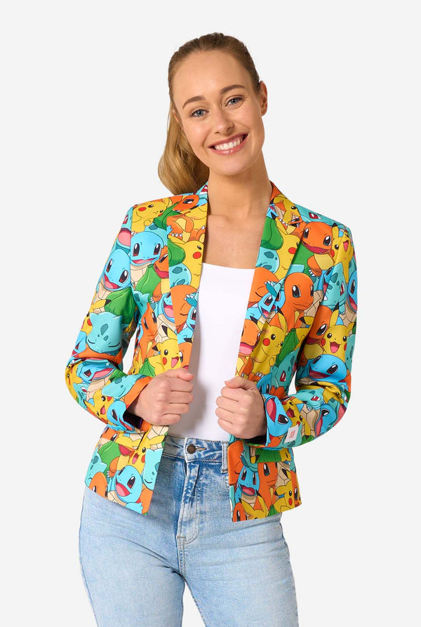Vrouw draagt een veelkleurige pokemonblazer met personages als pikachu, squirtle, charmander en bulbasaur. Ze houdt het jasje vast en lacht in de camera.