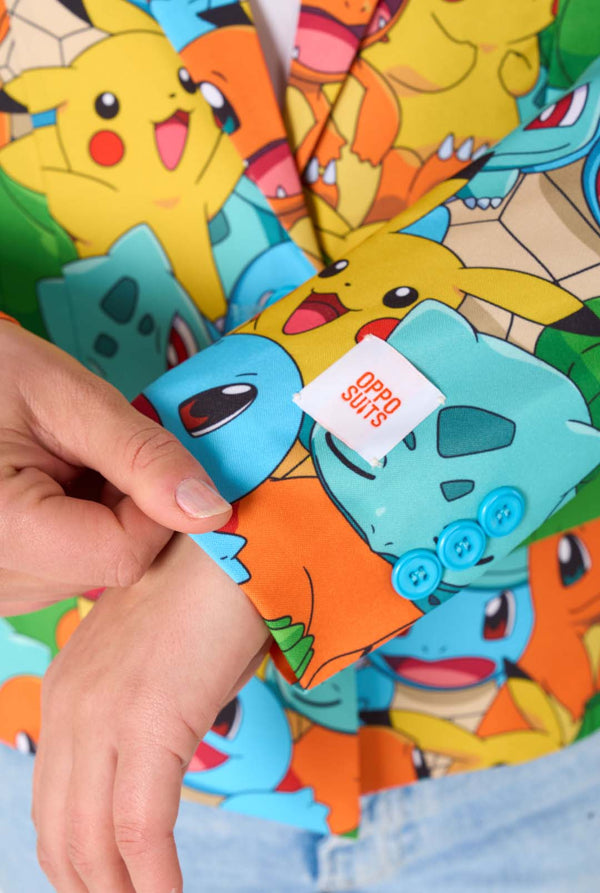Vrouw draagt een veelkleurige pokemonblazer met personages als pikachu, squirtle, charmander en bulbasaur. Op de mouw gefocust