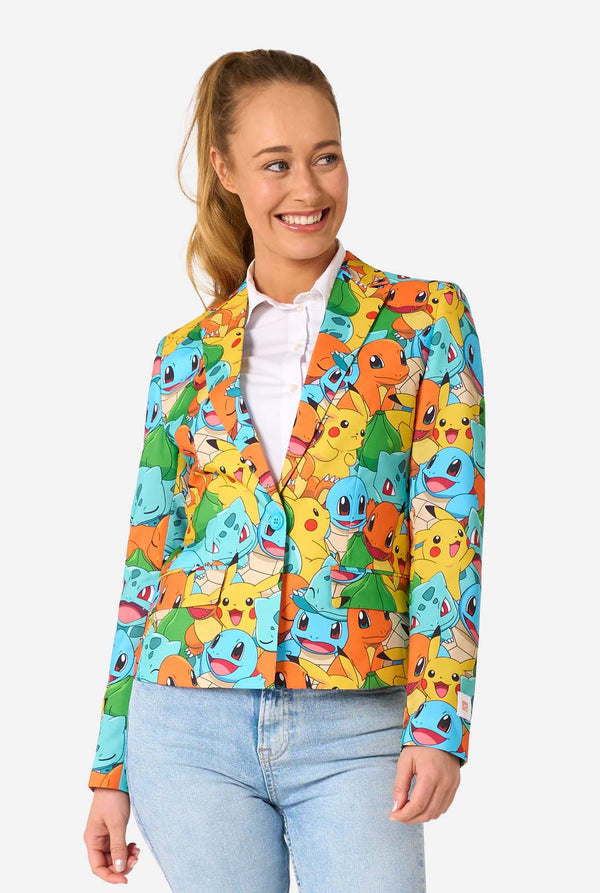 Vrouw draagt een veelkleurige pokemonblazer met personages als pikachu, squirtle, charmander en bulbasaur. Kijkt lachend naar de zijjkant