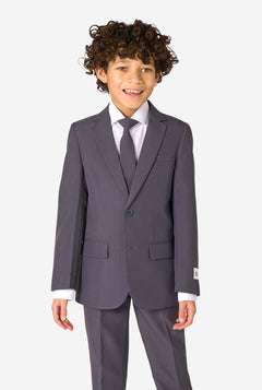 Een kind in een stijlvol antracietgrijs pak met een wit overhemd, vol zelfvertrouwen lachend. De perfecte formele outfit voor speciale gelegenheden, bruiloften en feestjes voor jongens.