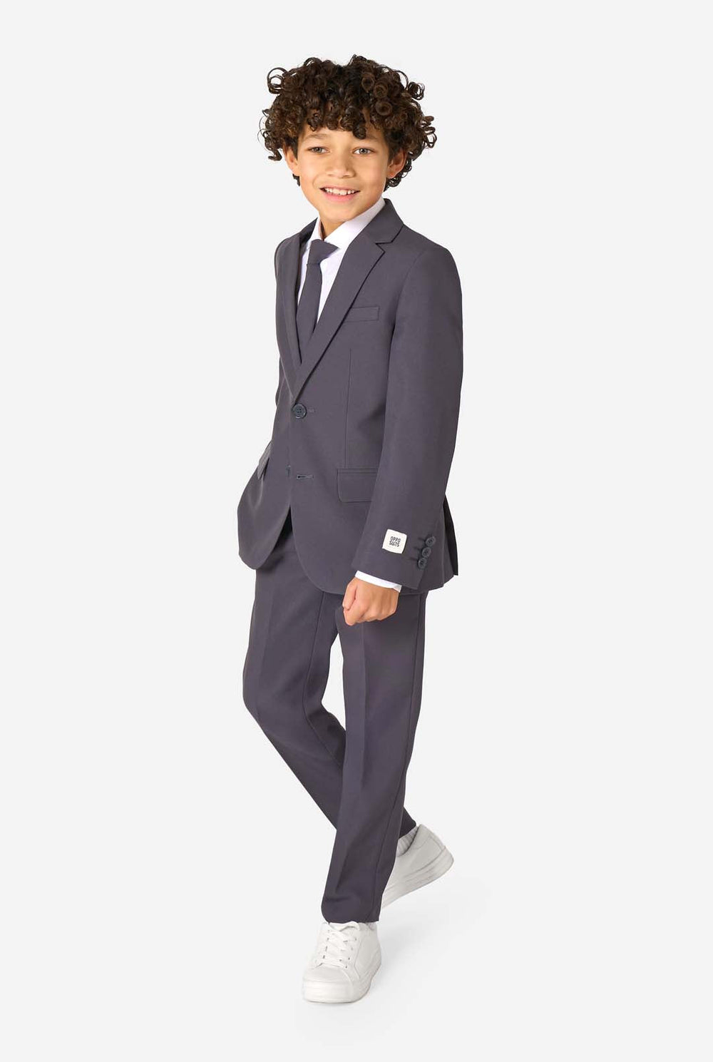Een kind in een stijlvol antracietgrijs pak met een wit overhemd, vol zelfvertrouwen lachend. De perfecte formele outfit voor speciale gelegenheden, bruiloften en feestjes voor jongens.