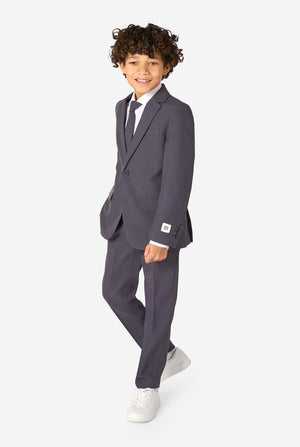 Een kind in een stijlvol antracietgrijs pak met een wit overhemd, vol zelfvertrouwen lachend. De perfecte formele outfit voor speciale gelegenheden, bruiloften en feestjes voor jongens.