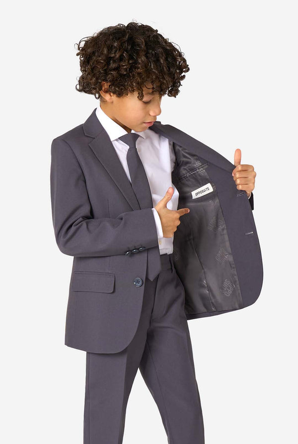 Een kind in een stijlvol antracietgrijs pak met een wit overhemd, vol zelfvertrouwen lachend. De perfecte formele outfit voor speciale gelegenheden, bruiloften en feestjes voor jongens.