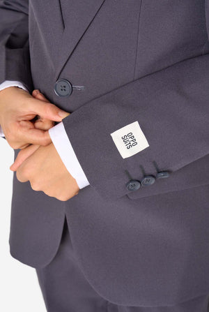 Een kind in een stijlvol antracietgrijs pak met een wit overhemd, vol zelfvertrouwen lachend. De perfecte formele outfit voor speciale gelegenheden, bruiloften en feestjes voor jongens.