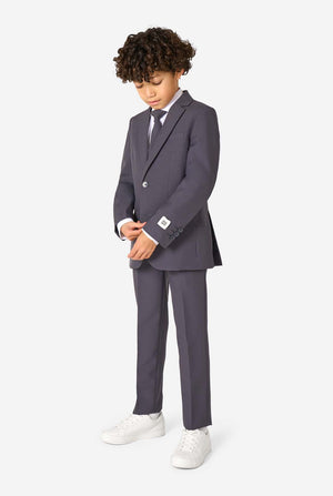 Een kind in een stijlvol antracietgrijs pak met een wit overhemd, vol zelfvertrouwen lachend. De perfecte formele outfit voor speciale gelegenheden, bruiloften en feestjes voor jongens.