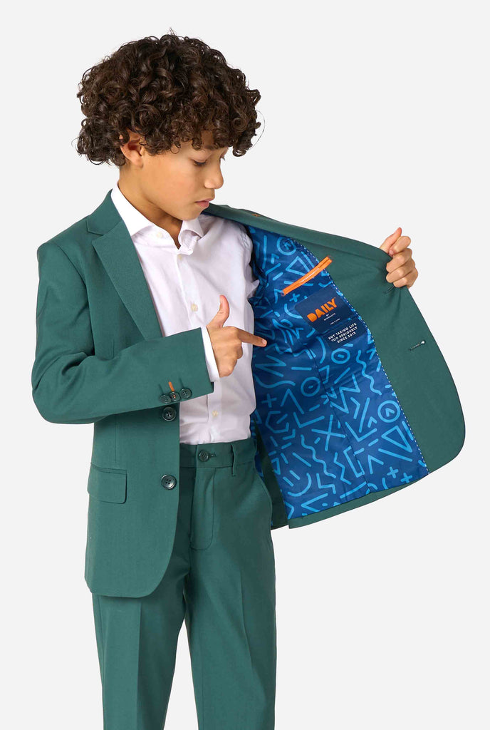 Een kind in een stijlvol donkergroen pak met een wit overhemd, wegkijkend van de camera. Perfecte formele outfit voor speciale gelegenheden, bruiloften en feestjes voor jongens. Houd een kant van het jasje open.