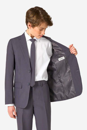 Een tienerjongen in een stijlvol antracietgrijs pak met een wit overhemd, vol zelfvertrouwen lachend. De perfecte formele outfit voor speciale gelegenheden, bruiloften en feestjes.