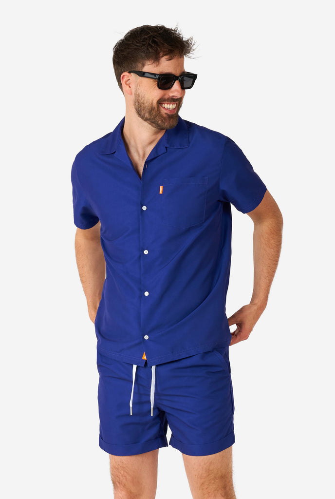 Man wearing blue summer set, consisting of shorts and shirt