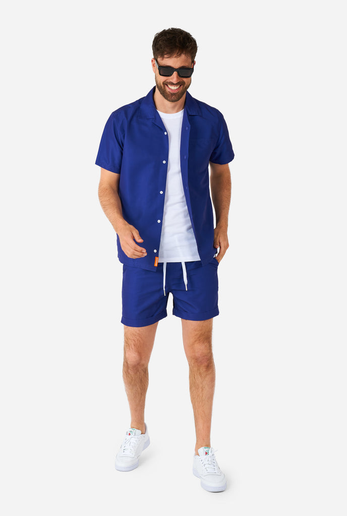 Man wearing blue summer set, consisting of shorts and shirt