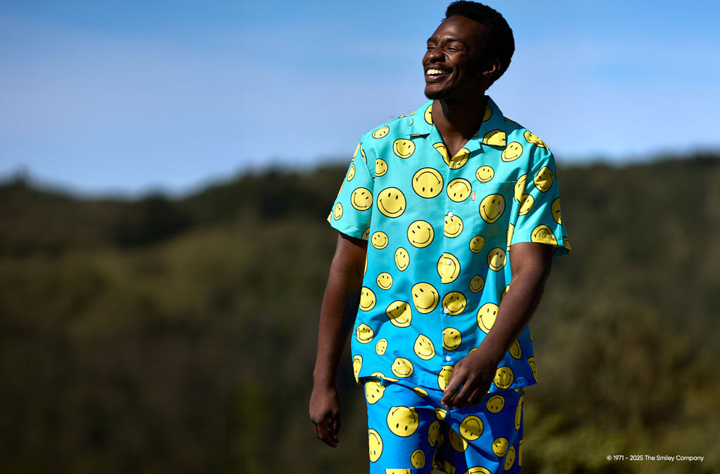 Foto van man die een blauwe zomer set met Smiley print draagt.