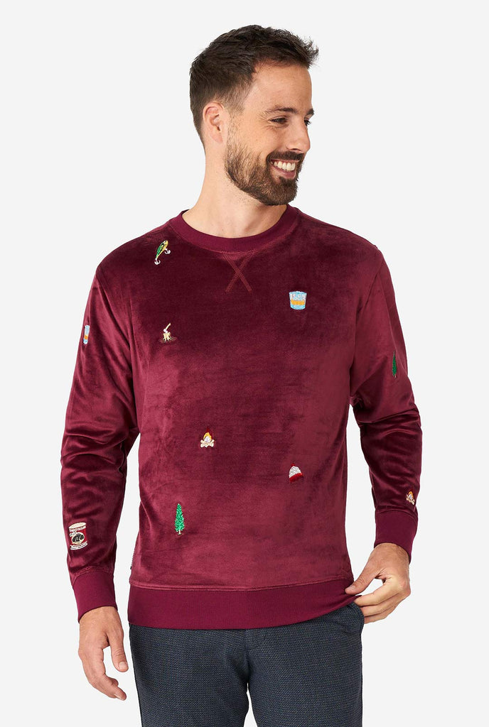 Man draagt ​​Velver Bourgondië Red Christmas Sweater met kerstpictogrammen