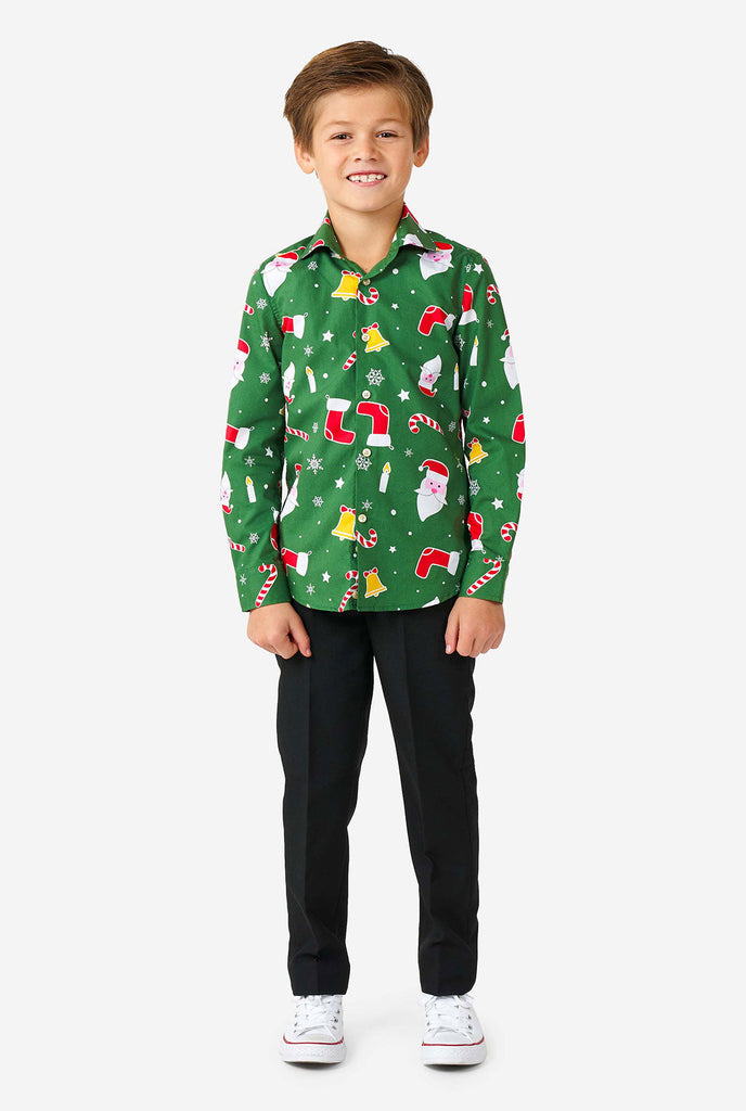 Kind draagt ​​een groen kerstshirt met kersticonen
