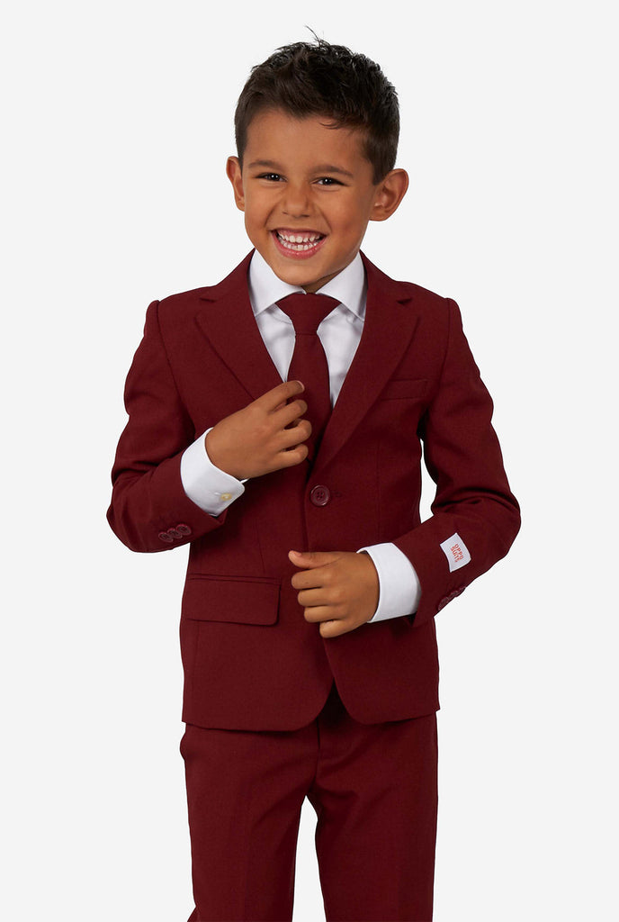 Kind draagt ​​een bordeauxrood rood pak voor jongens