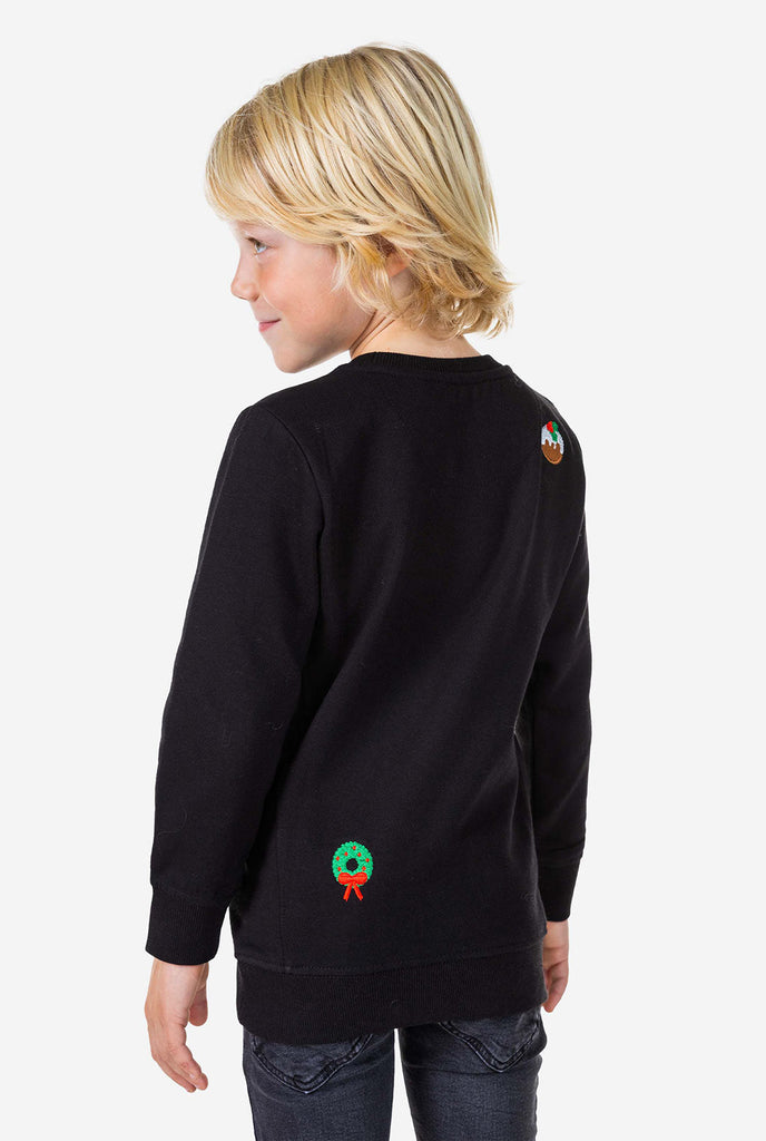 Kind draagt ​​een zwarte kersttrui met kerstpictogrammen, bekijk vanaf de achterkant