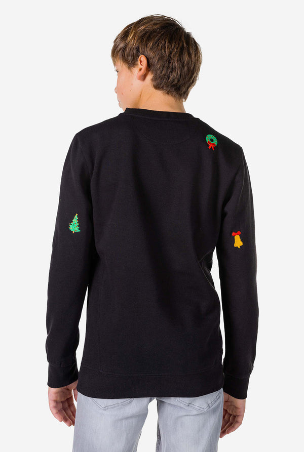 Tiener draagt ​​een zwarte kersttrui met kerstpictogrammen, bekijk vanaf de achterkant
