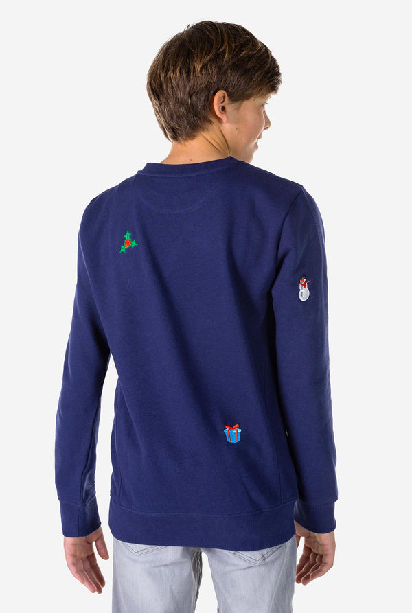 Kind draagt ​​een blauwe kersttrui met kerstpictogrammen, bekijk vanaf de achterkant