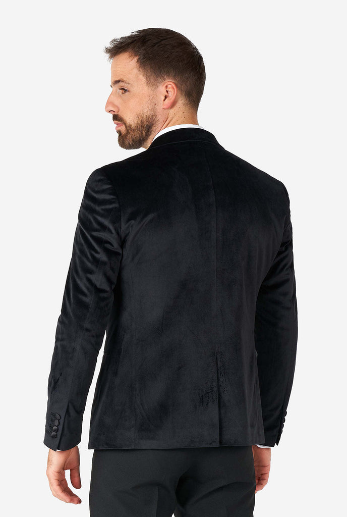 Man draagt ​​een zwarte fluwelen dinerjack blazer, bekijk vanaf de achterkant