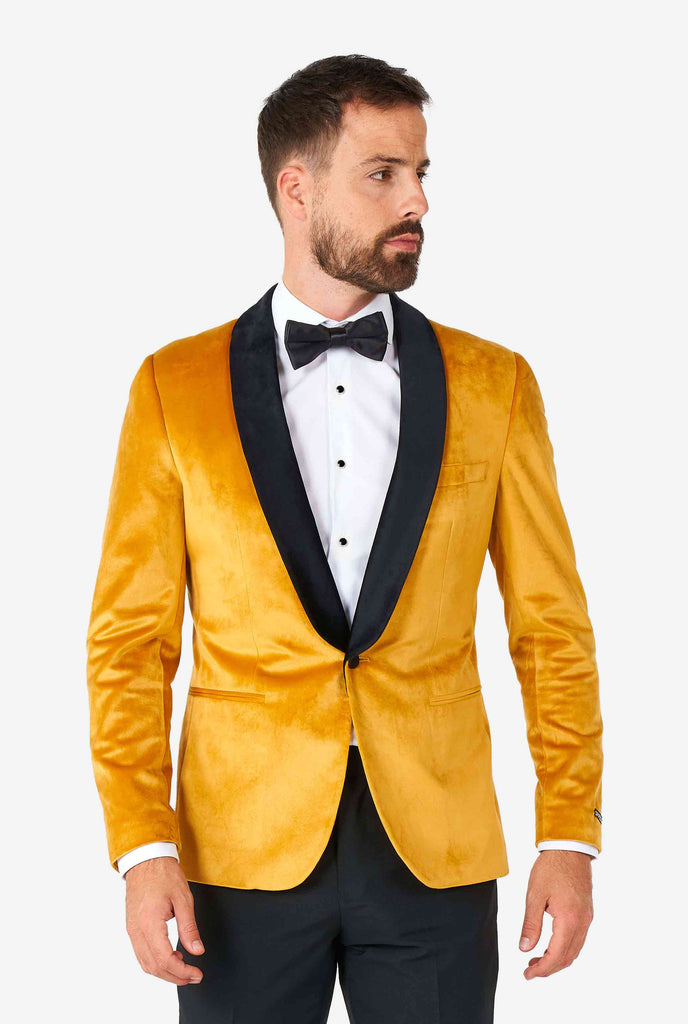 Man draagt ​​een gouden fluwelen dinerjack blazer