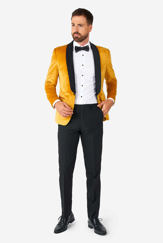Man draagt ​​een gouden fluwelen dinerjack blazer