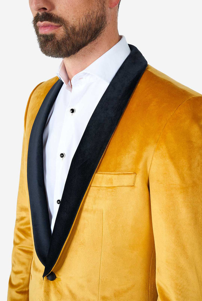 Man draagt ​​een gouden fluwelen dinerjack blazer, close -up