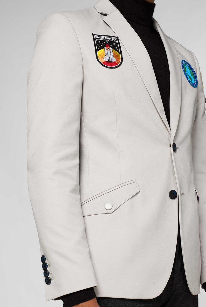 Grijze blazer met patches met astronaut thema's die dichtbij worden weergegeven