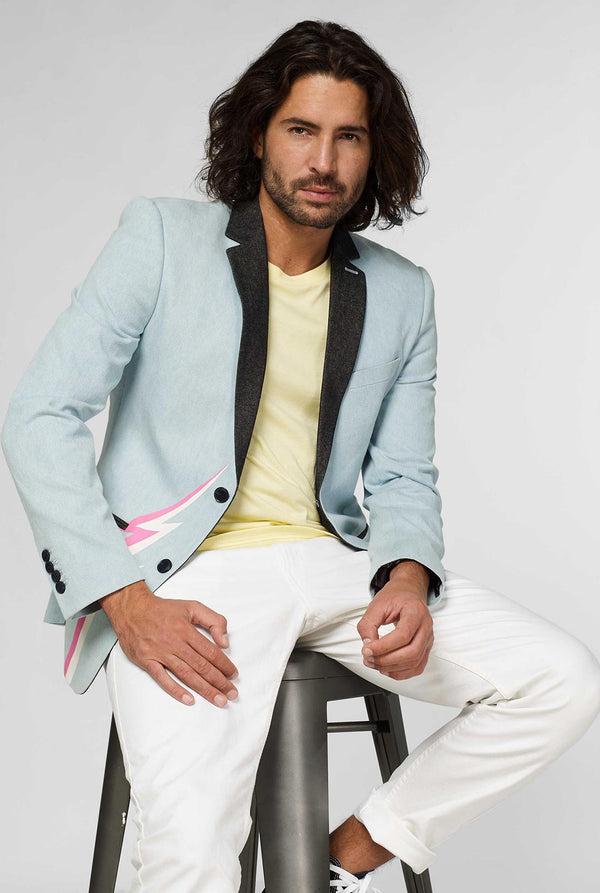 Blauwe casual blazer met witte en roze bliksemschicht gedragen door man zittend op een kruk