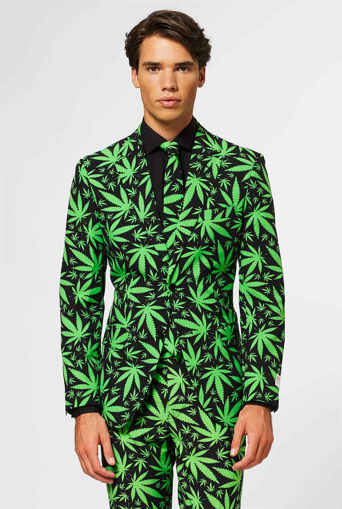 Man draagt ​​een zwart herenpak met groene cannabisprint