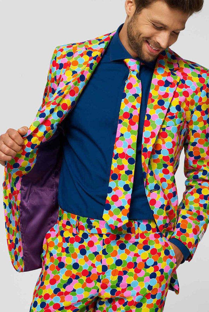 Man draagt ​​herenpak met confetti -print en blauw overhemd