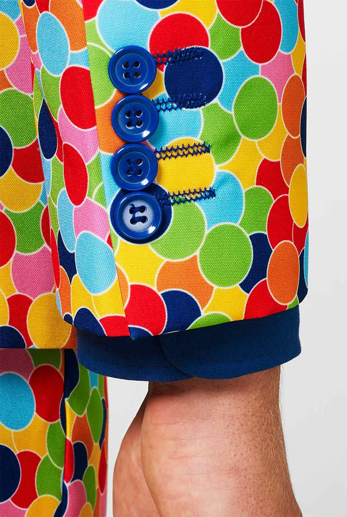 Man draagt ​​herenpak met confetti -print en blauw overhemd, mouw close -up