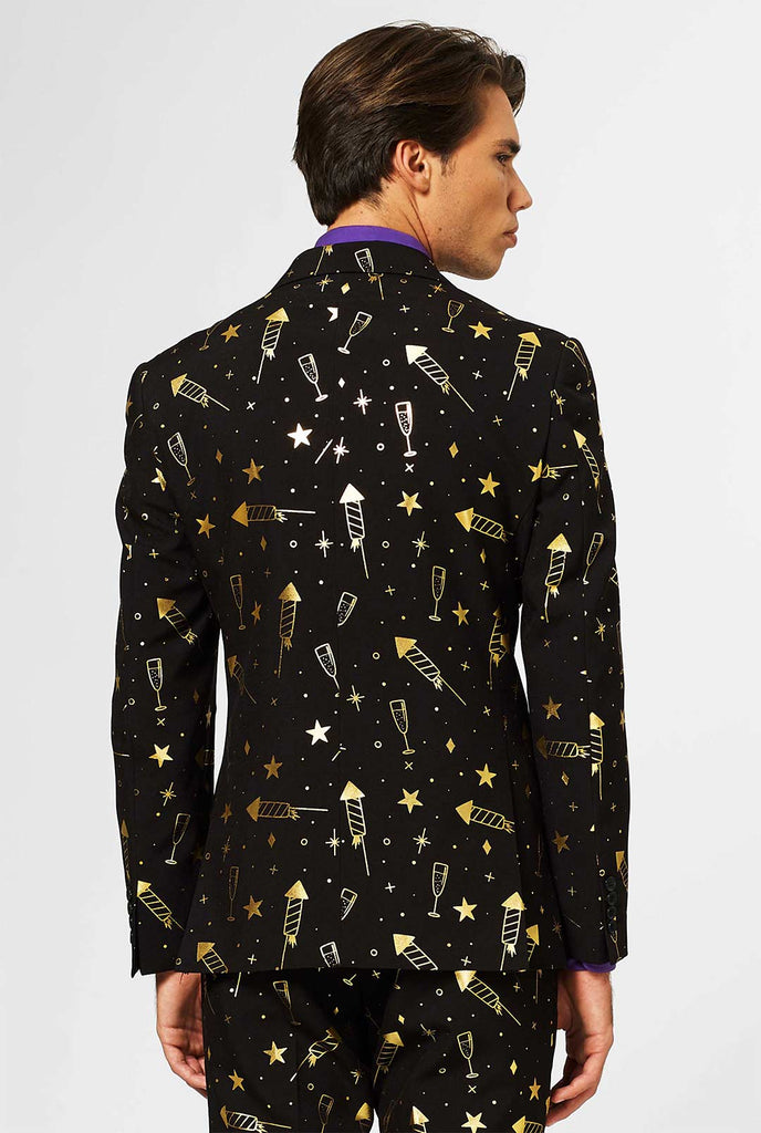 Zwart herenpak met gouden vuurwerkafdruk gedragen door de mens, zicht vanaf de achterkant