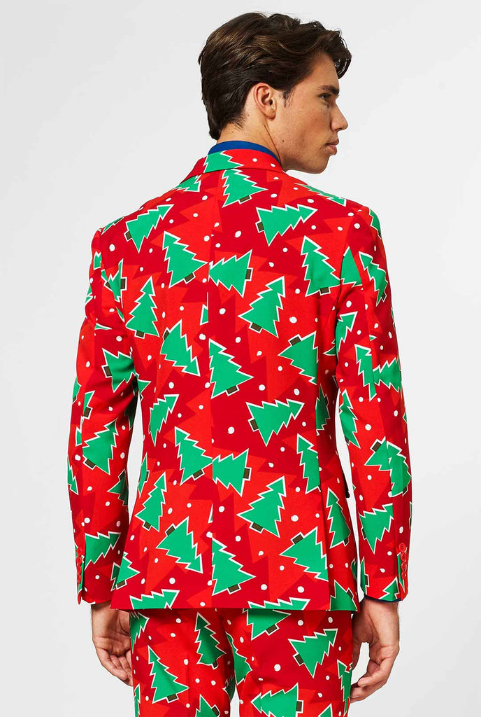 Rood kerstpak met dennenboomafdruk gedragen door de mens van achteren getoond